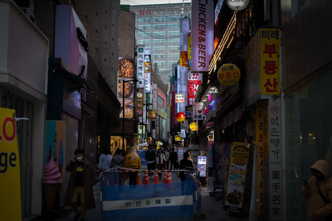 Busy Myeongdong shopping street at night with colorful store signs and crowds